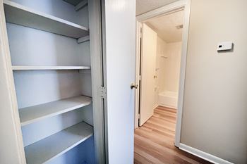 A white refrigerator with four shelves is open.